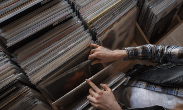 female hands browsing vinyl records in a store