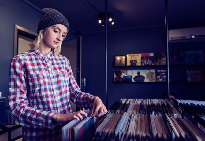beautiful young woman browsing records in the vinyl record store